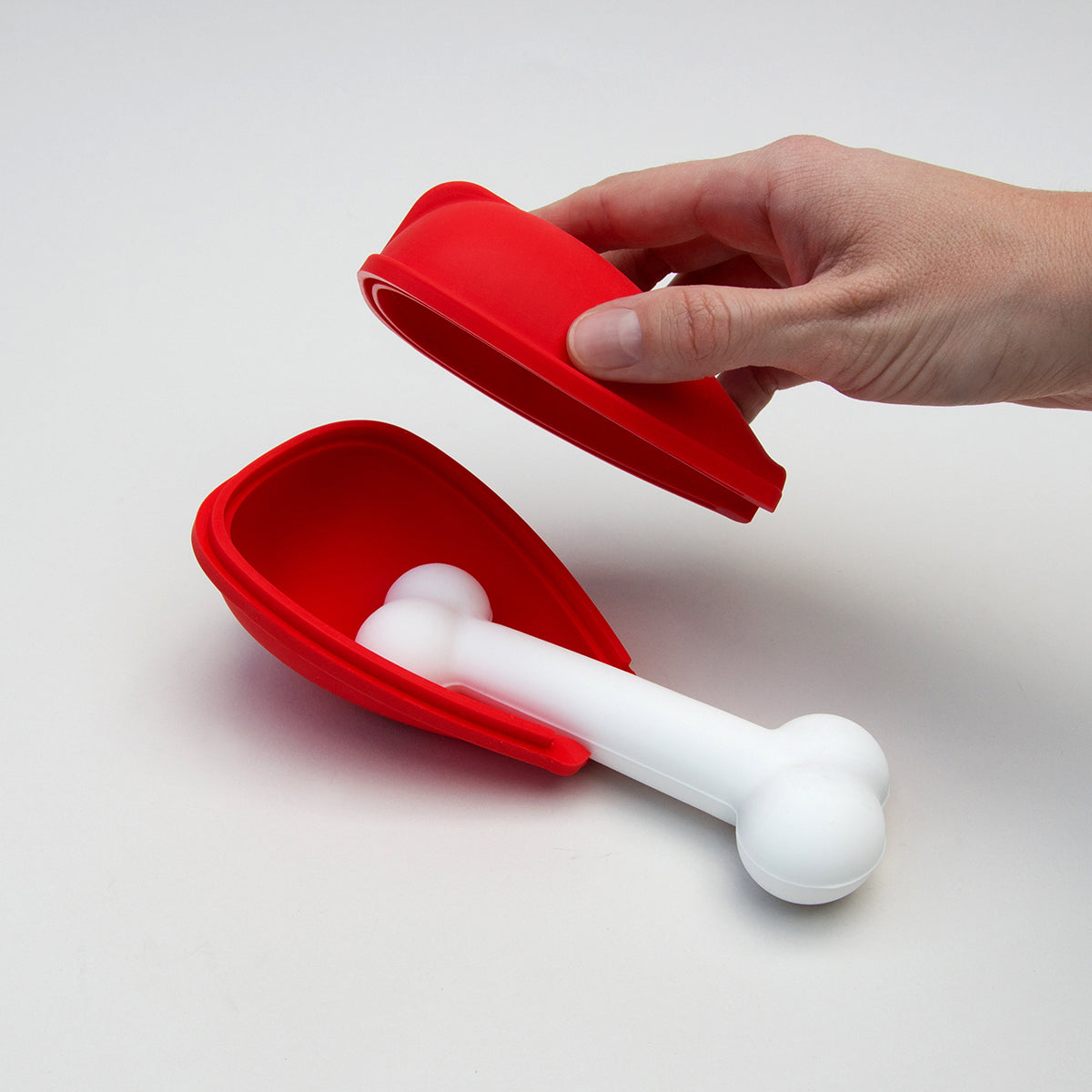 Dog enjoying a bone-shaped popsicle made with the Pupsicle Ice Lolly Maker, a silicone mold designed for pet-friendly frozen treats.