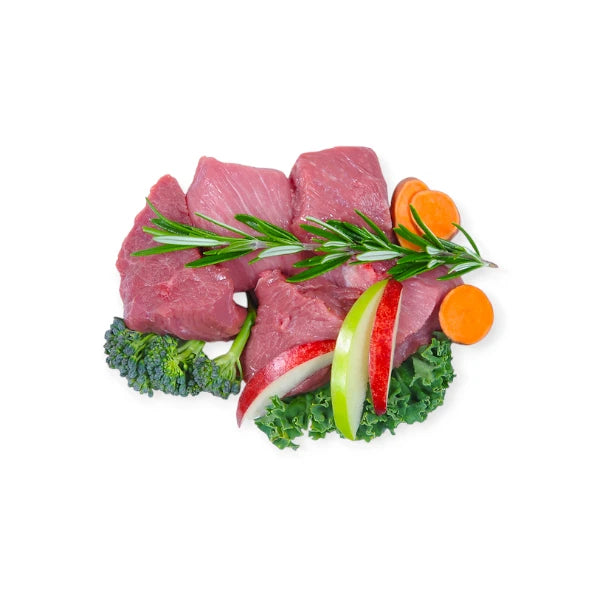 Fresh lamb, broccoli, apple slices, carrots, and kale ingredients used in Woof Lamb Dog Treats.
